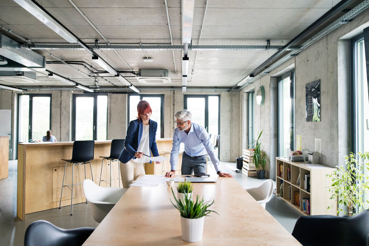 Image montrant un espace de bureaux moderne dans un local d’entreprise utilisé pour une SCI. Le bureau est aménagé avec des postes de travail équipés d’ordinateurs, de chaises ergonomiques, et d’espaces de rangement.