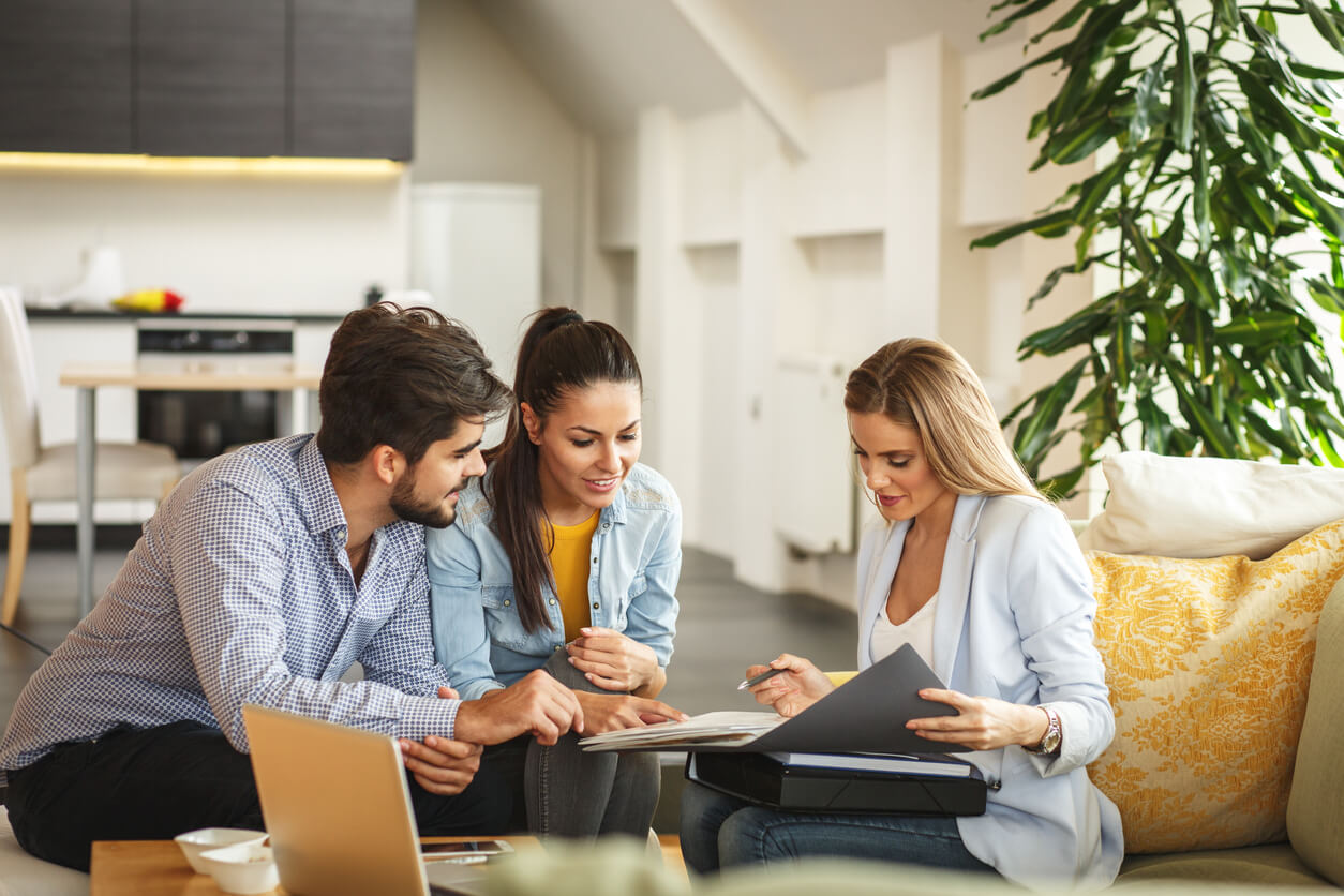 Un groupe d'associés se réunit autour d'une table, consultant des documents importants liés à leur Société Civile Immobilière (SCI) tout en discutant de la gestion de leur compte bancaire SCI, illustrant ainsi la collaboration et la transparence dans leur projet immobilier commun.