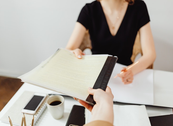 Un investisseur tend un document à un professionnel pour qu'il analyse le rendement locatif de son investissement locatif à Metz.