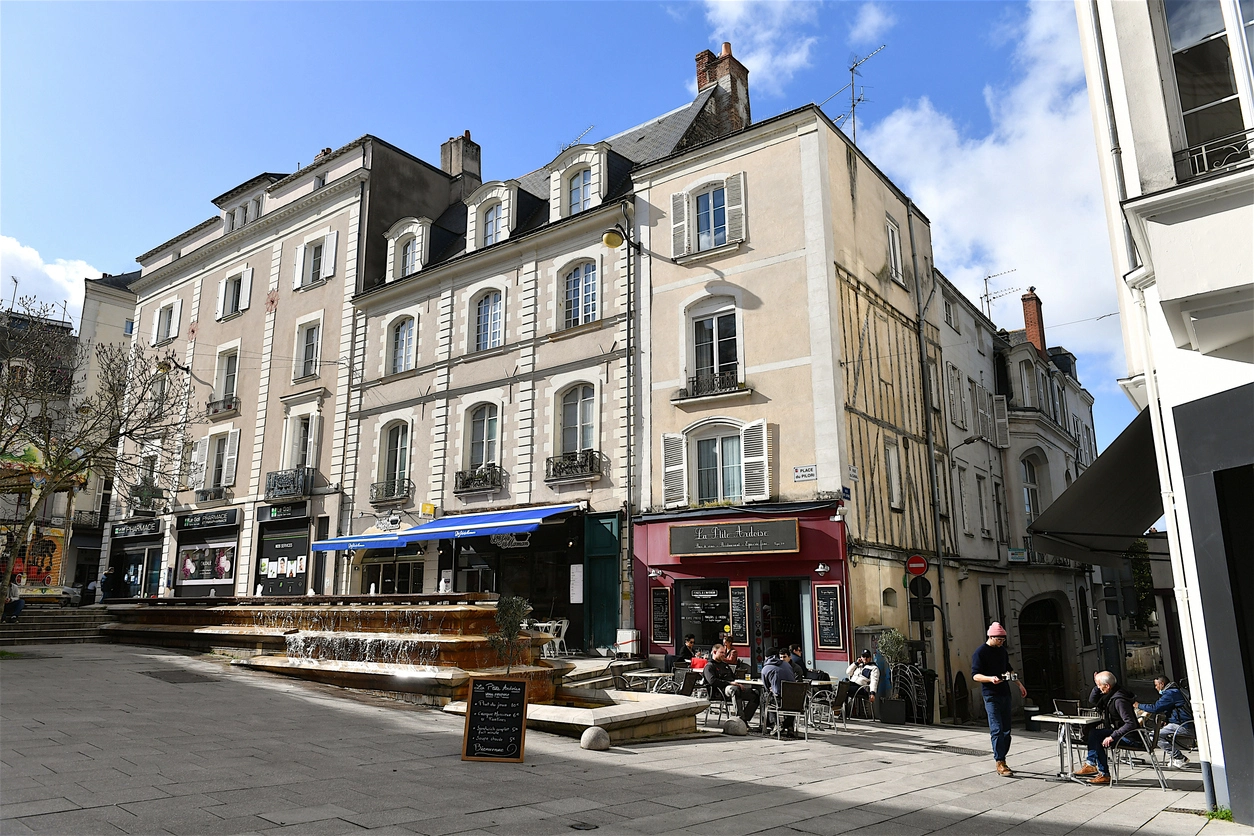 Une place animée au centre-ville d'Angers, montrant des bâtiments historiques, des terrasses et commerces. L’image montre un cadre idéal pour un investissement locatif Angers