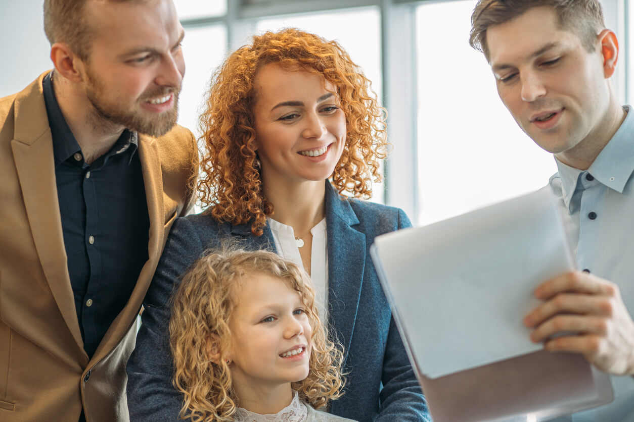 Une famille en discussion avec un expert en gestion immobilière, échangeant des conseils sur comment optimiser la location de biens grâce à une SCI familiale.