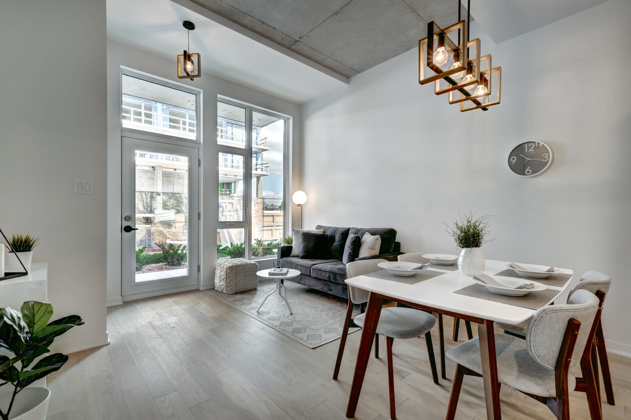 Vue intérieure d'un appartement avec un salon spacieux et une table à manger, illustrant les avantages d'acheter un appartement en SCI.