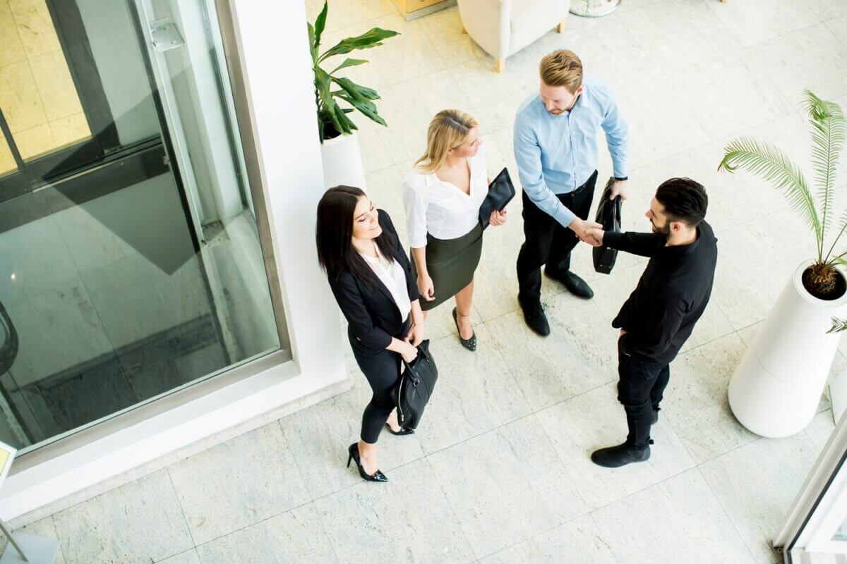 Associés discutant à la sortie de l'entreprise, échangeant sur la vente de parts sociales et les démarches légales à suivre pour finaliser la cession.