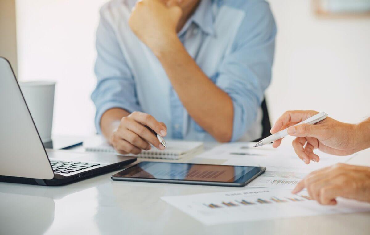 Deux personnes en pleine analyse de documents et de chiffres liés au revenu foncier SCI, travaillant à optimiser la gestion fiscale et les rendements immobiliers.