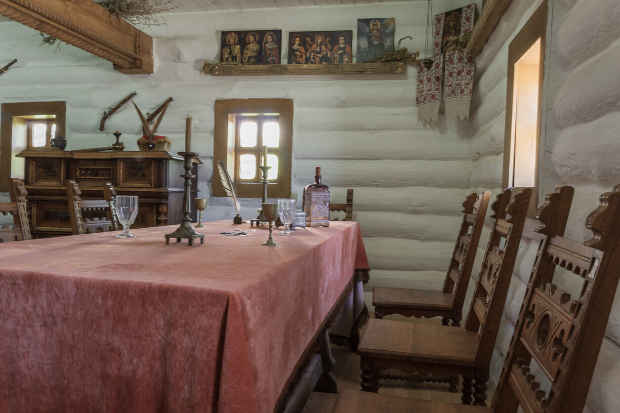 image d'une salle à manger avec une table recouverte de nappe rouge, ainsi que des chaises en bois et des murs en bois pour illustrer le mot clé durée amortissement lmnp ancien. 