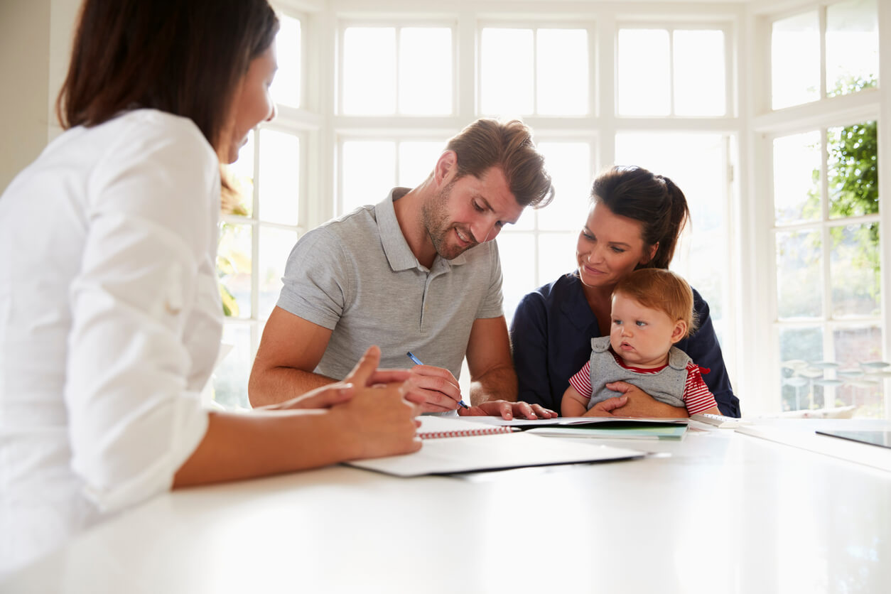 Image montrant une famille réunie autour de documents officiels liés à la cession des parts d’une SCI. Un conseiller les guide à travers les étapes de transmission, soulignant les aspects juridiques et fiscaux.