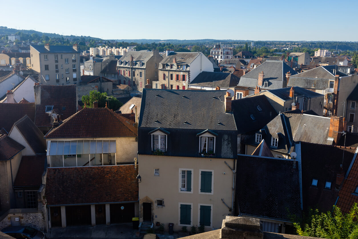 Vue panoramique des toits d'immeubles anciens et modernes, illustrant le potentiel d'investissement locatif Montluçon dans un cadre immobilier attractif