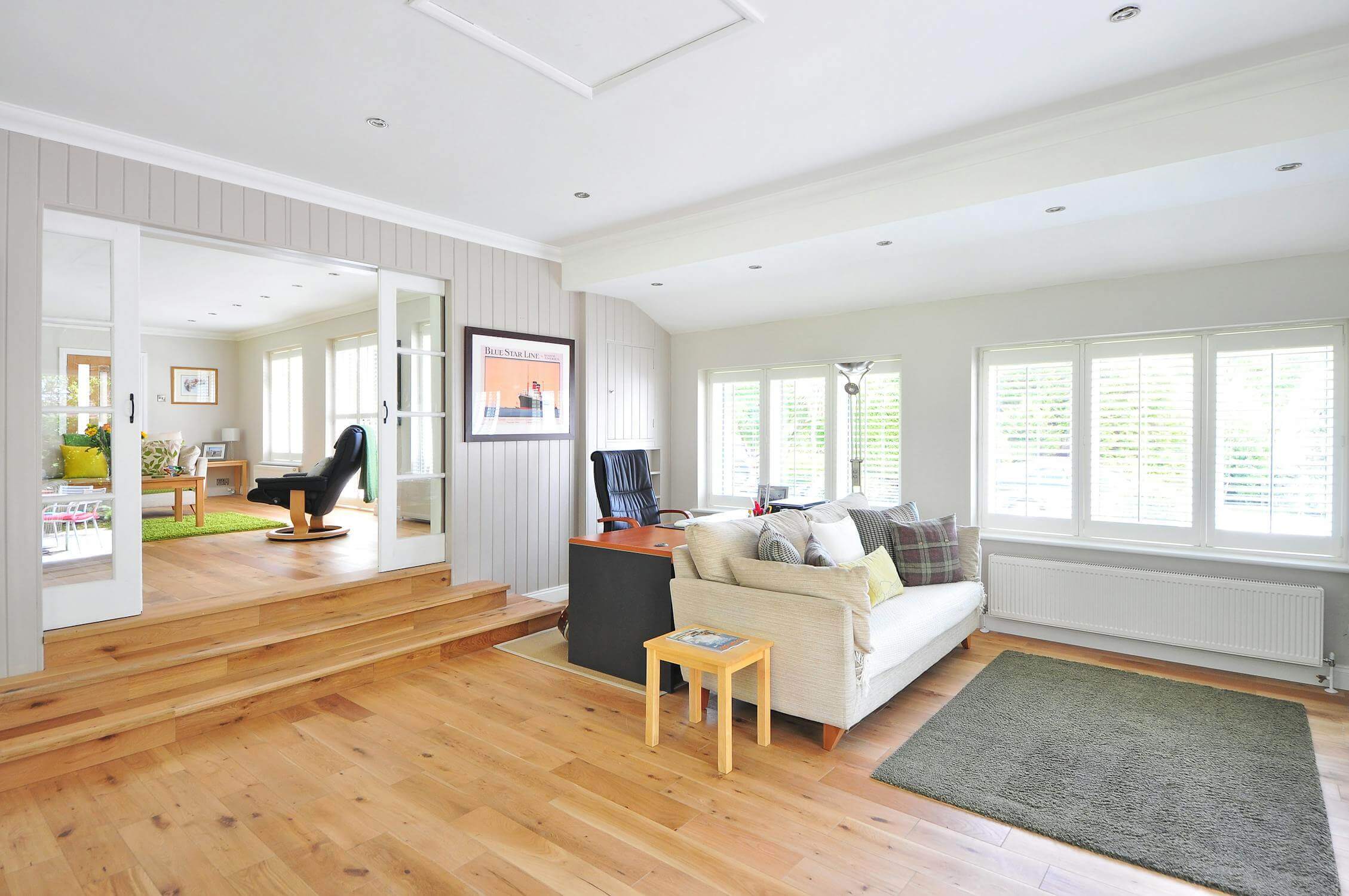 Photo d'un appartement meublé avec un sofa blanc et un sol en parquet. cet appartement est disponible pour une location meublée. comment devenir LMNP. 